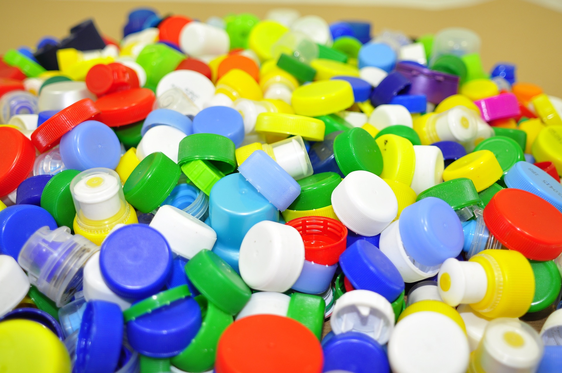 Närbild på en stor mängd plastkorkar i olika färger.